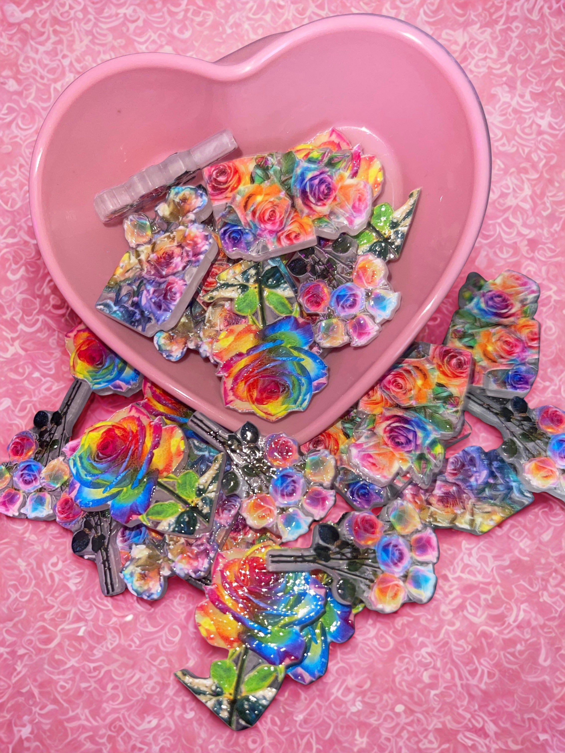 Rainbow rose beads in pink heart bowl on pink swirl background