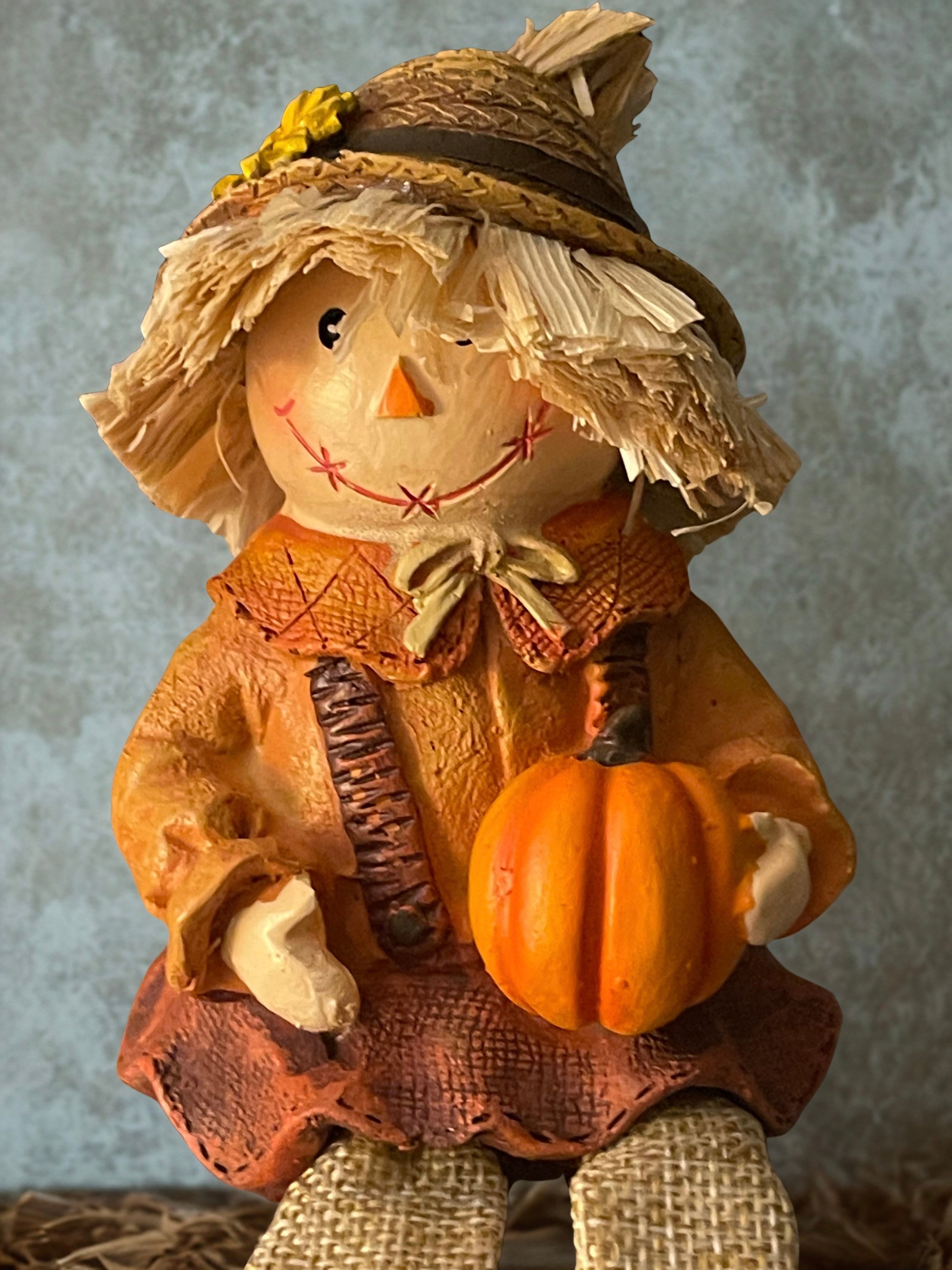Three raggedy scarecrow shelf sitters displayed together on rustic wood surface with brick wall background
