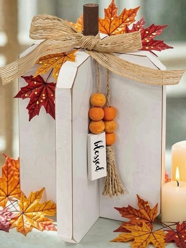 Blessed white wooden pumpkin with fall leaf accents and candle