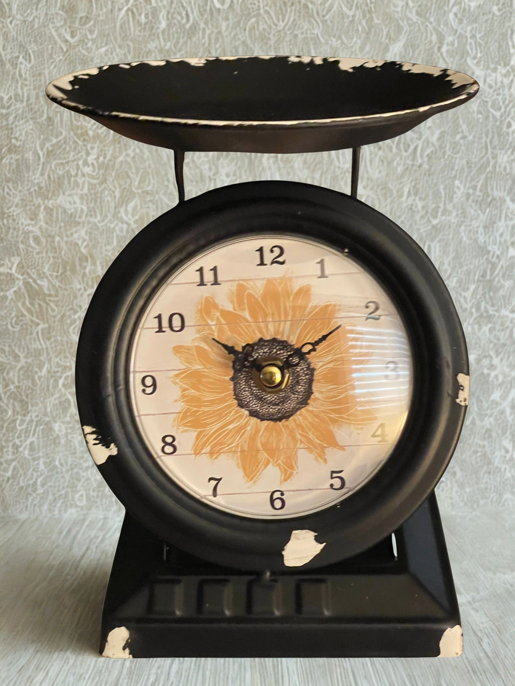 Vintage sunflower scale clock close-up of clock face showing sunflower and filigree hands