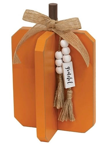 Grateful orange wooden pumpkin styled with red apples and candles