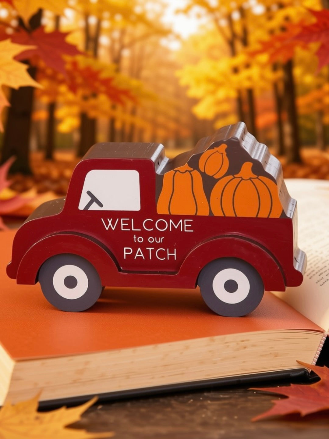 Welcome to Our Patch red truck sitter on open book with golden fall foliage background