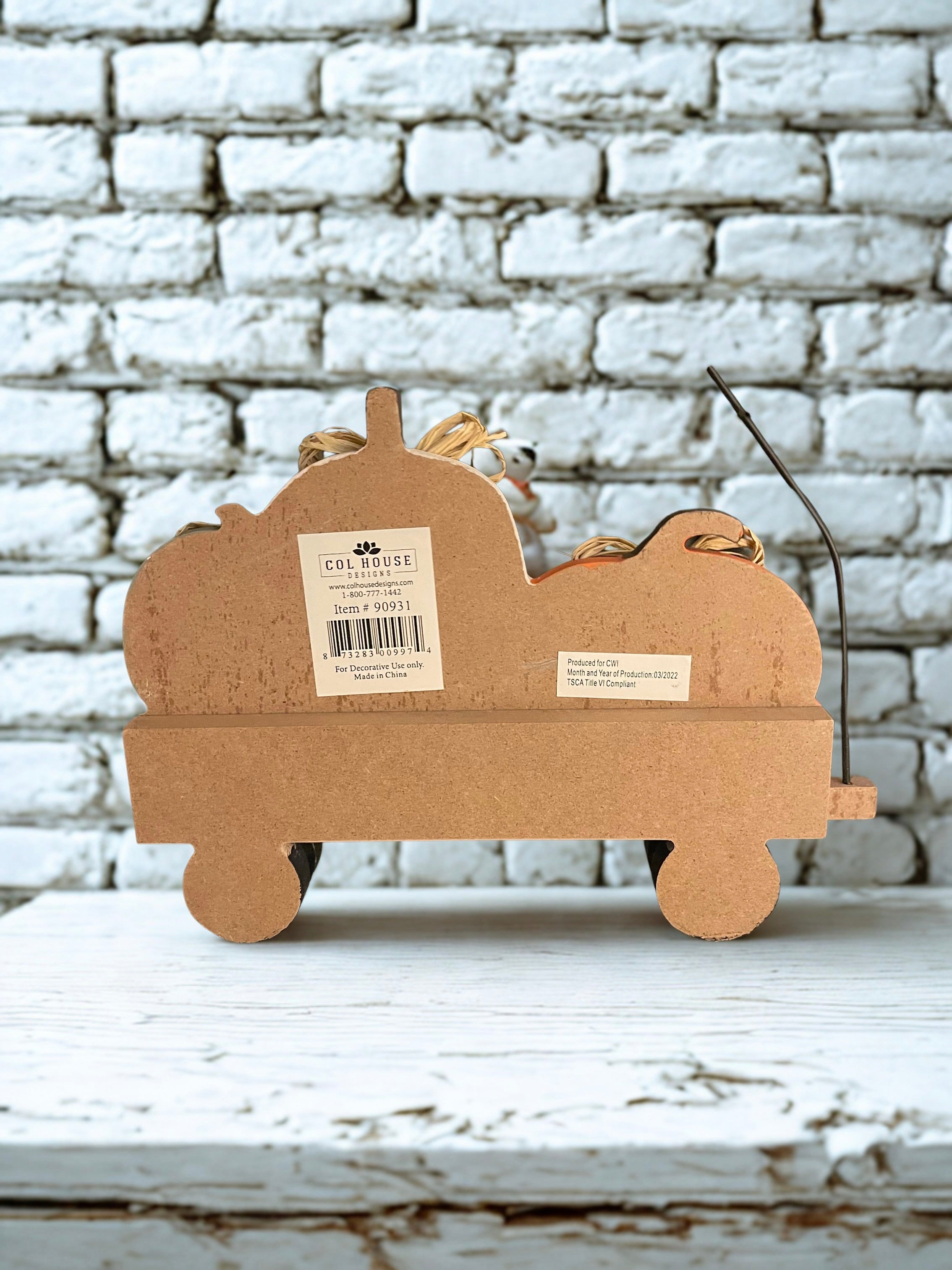 Back of Happy Harvest pumpkin wagon sitter showing Col House Designs label and item number