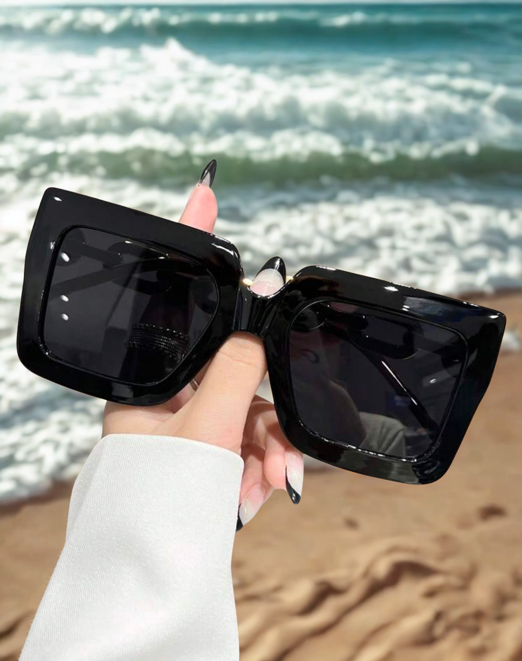 Chain Reaction Sunglasses held at beach