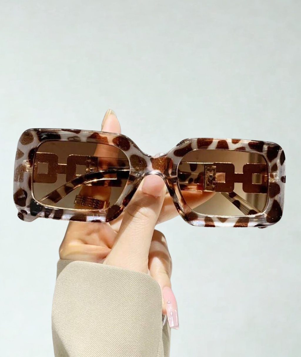Wild Luxe Rectangle Sunglasses held up showing leopard print frame