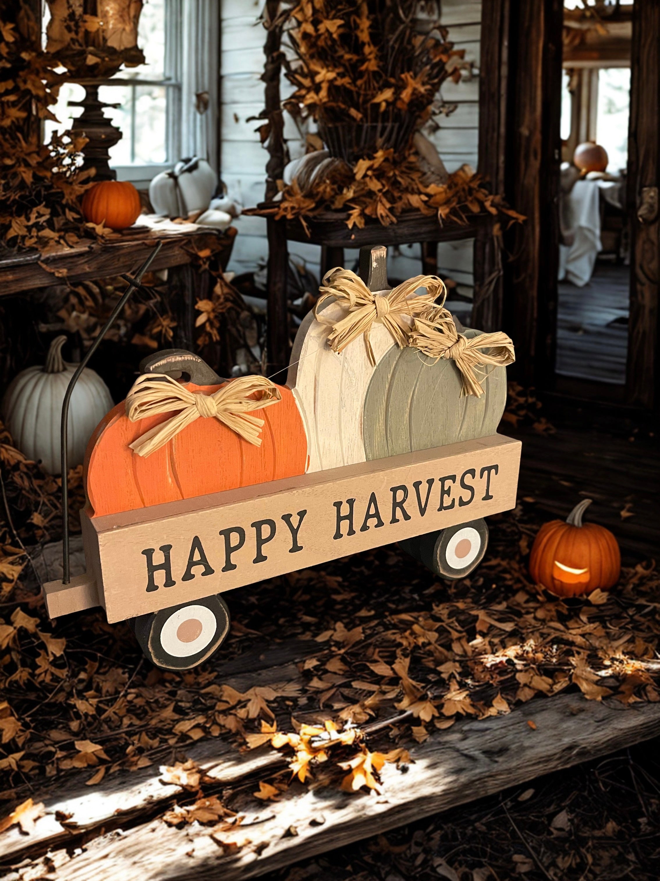 Happy Harvest pumpkin wagon sitter styled in fall porch setting with orange leaves