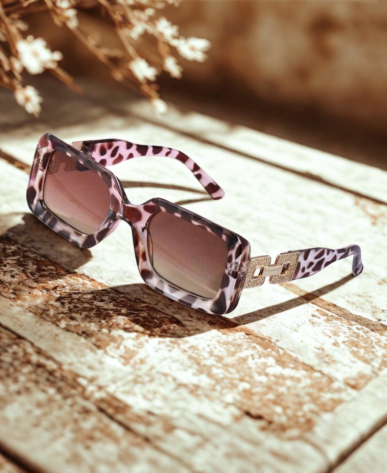Wild Luxe Rectangle Sunglasses on stone surface with dried flowers