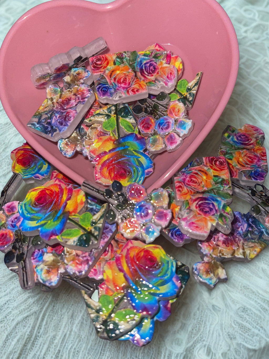 Holographic rainbow rose beads close up showing vibrant colors on white lace