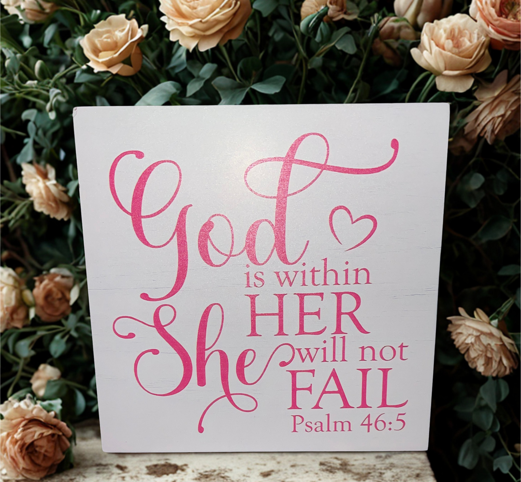 Psalm 46:5 wooden block sign among colorful daisies on a weathered wooden surface