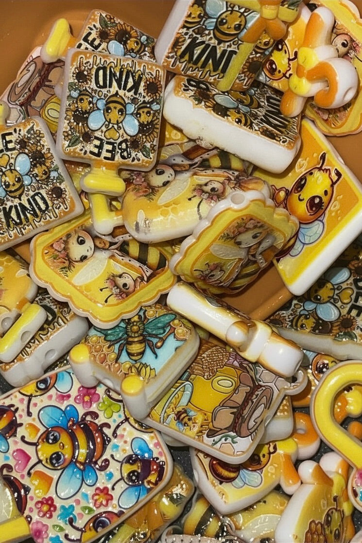 Honey bee bead charms close up in orange bowl