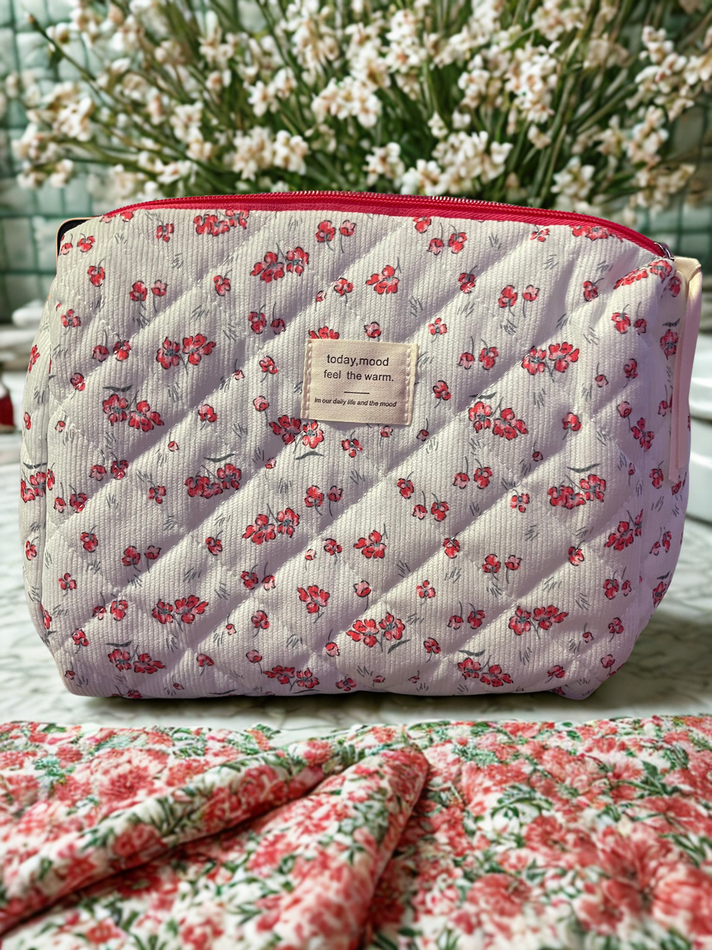 Floral quilted corduroy makeup bag - styled on marble with gold accessories