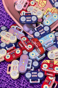 Colorful retro boombox beads spilling from a pink bowl on purple lace background