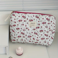 Floral quilted corduroy makeup bag - styled on white surface with flower decor
