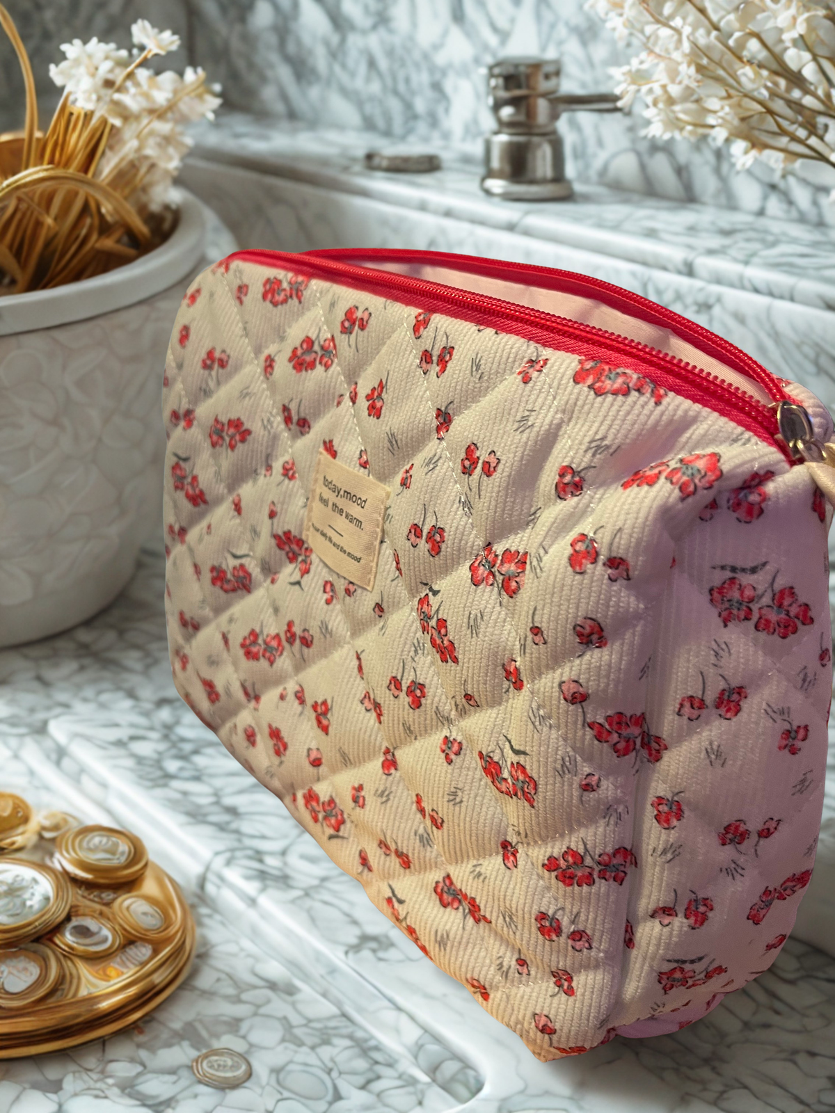 Floral quilted corduroy makeup bag - side angle on marble vanity