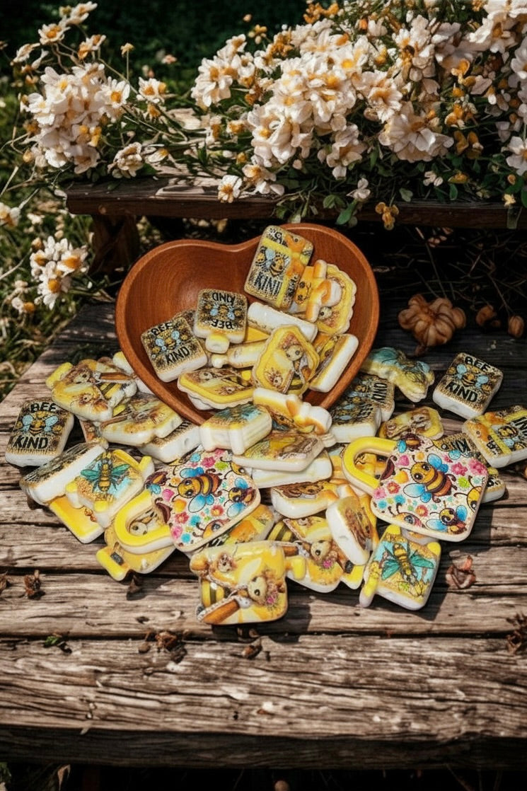 Honey bee bead charms in wooden heart bowl with flowers