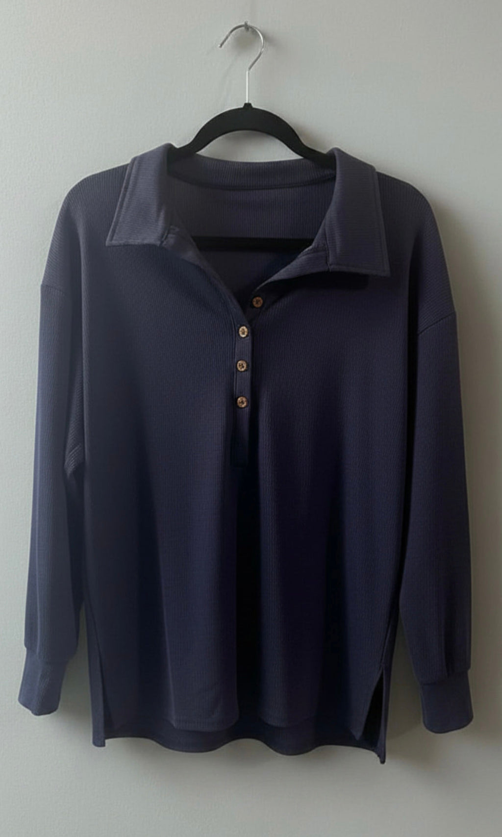 Loose lapel buttoned top on hanger - navy blue back view