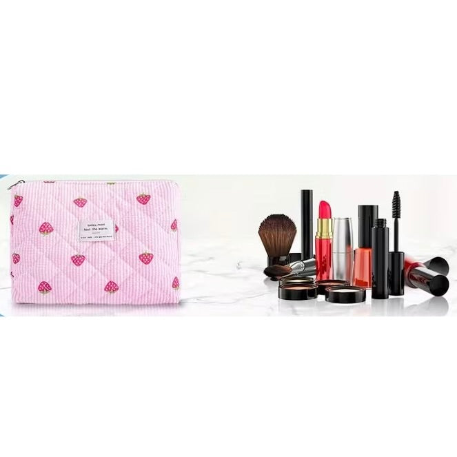 Large strawberry quilted train case makeup bag shown with cosmetics